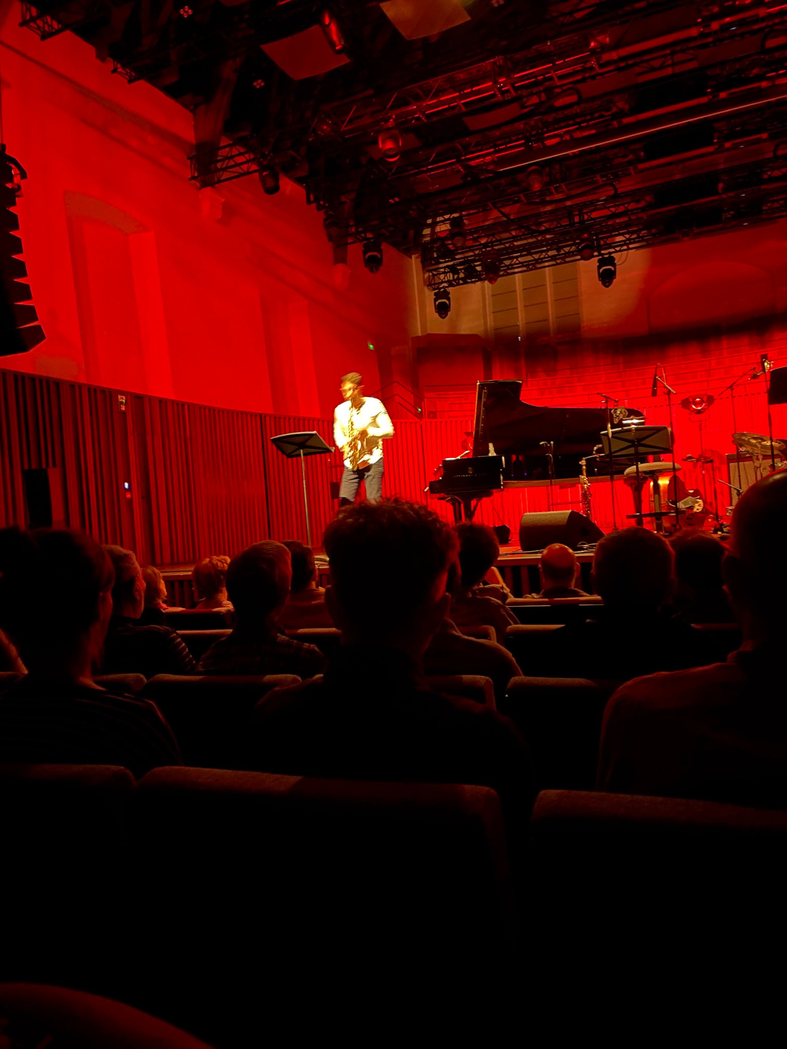 Alberto Cavallaro performing on a red-lit concert stage in front of an audience.