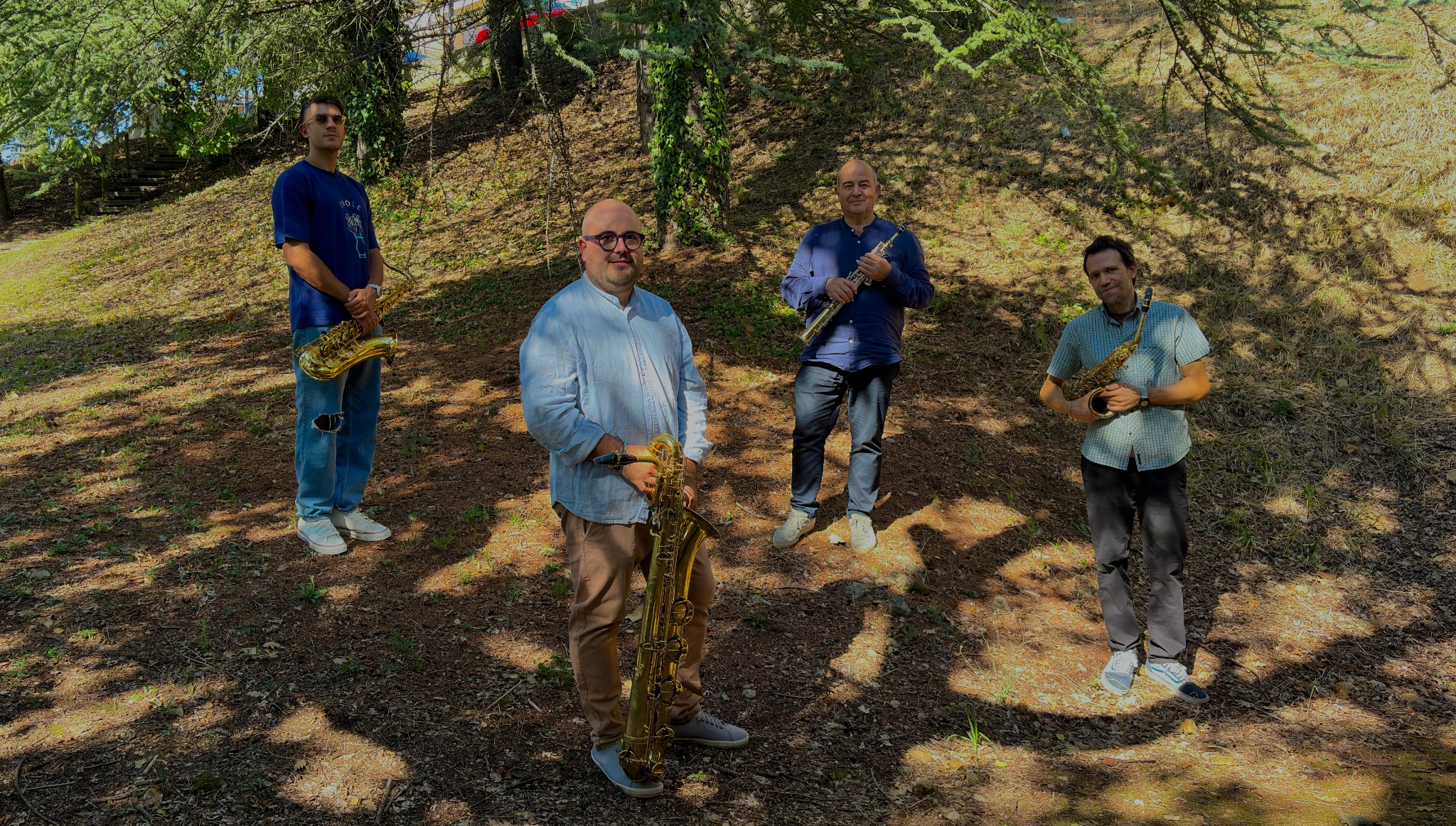 The four musicians of Sidera Saxophone Quartet with their saxophones outdoors.